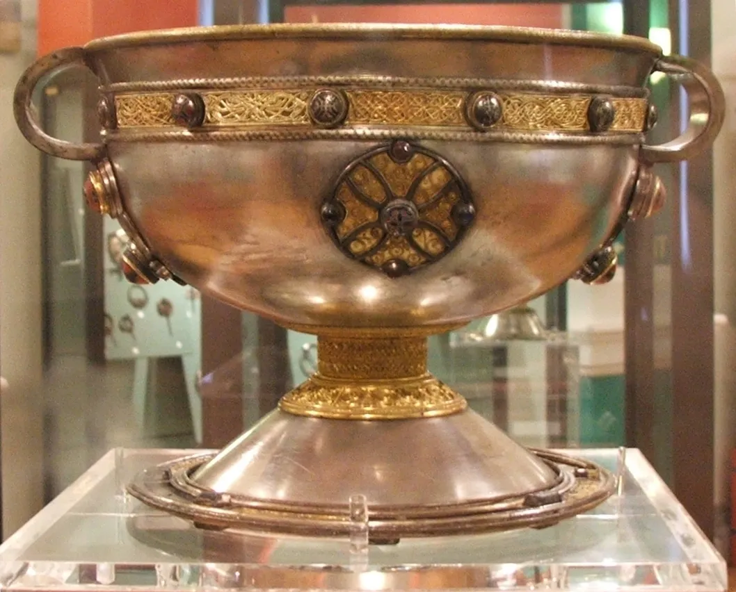 The Ardagh Chalice, a silver bowl featuring intricate gold filigree bands that mirror manuscript interlace.